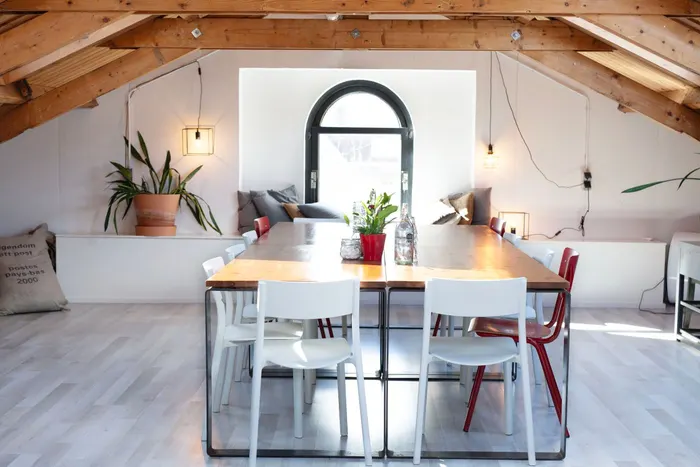 Ausgebautes Dachgeschoss mit sichtbaren Holzbalken und Esstisch