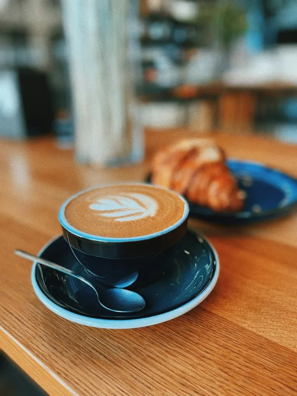 Cappuccino und Croissant auf einem Holztisch