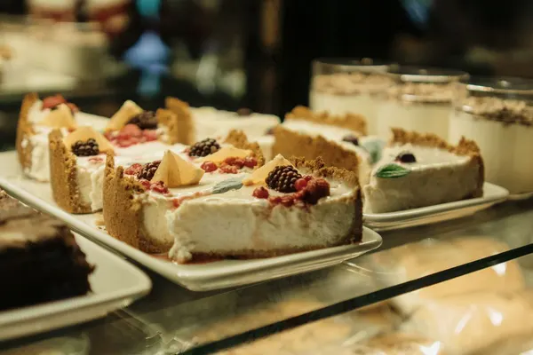 Auslage mit Käsekuchenstücken und frischen Beeren