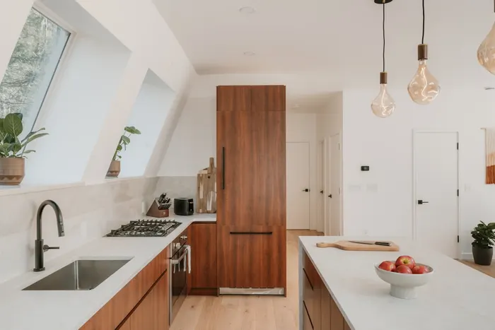 Helle Einbauküche mit Holzfronten und heller Arbeitsplatte